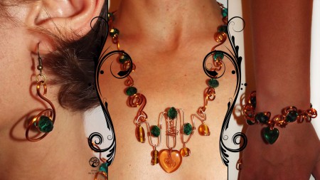 Parure Verbena  Collana interamente fatta a mano con filo in rame impreziosita con semicristalli verdi. Ciondoli con perle in vetro sui toni del marrone e cuore in vetro arancione/marrone. Orecchini e bracciale abbinati. Nichel free