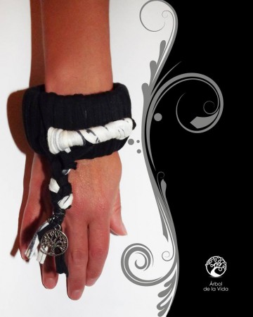 NERINA  Bracciale in fettuccia in cotone e acrilico nera con inserto in cotone bianco. Ciondolo con treccia e albero della vita in metallo.