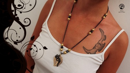 black and gold  Collana con catena nera impreziosita con perle color ero e semicristalli neri. Ciondolo con foglia color oro con albero della vita realizzato a mano colore nero. Materiali: metallo, acrilico, semicristalli, alluminio.